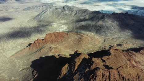 Aerial-View-of-Dry-Rocky-Cliffs-Above-Valley-WIth-Bonneville-Salt-Flats-on-Sunny-Day,-Revealing-Tilt-Up-Drone-Shot,-Utah-USA