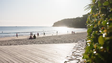 Popular-Destino-Turístico-Noosa-Encabeza-El-Paseo-Marítimo-De-La-Playa-Y-La-Arena-Con-Gente-Al-Atardecer,-Cámara-Lenta-De-4k