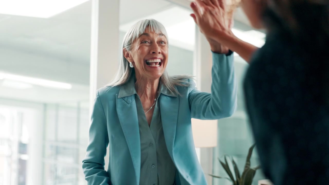 Senior Businesswoman Celebrating Success with High Five in Office