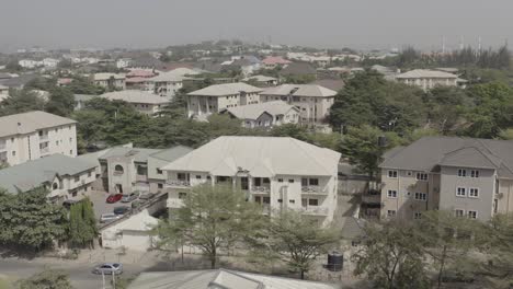 Aerial---Drone-moving-forward-of-houses-and-trees-at-a-low-angle