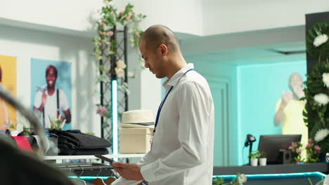 retail employee using tablet in clothing store