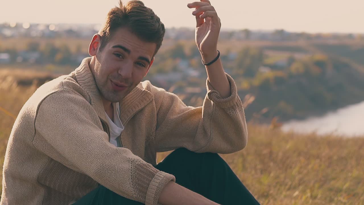 un bel ragazzo in depressione parla tenendo la mano sulla testa