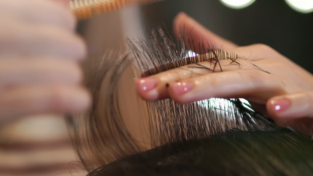 Close up of men's hair cutting scissors in a beauty salon. Frame. Close up of a haircut at a hair saloon. Professional barber styling hair of his client