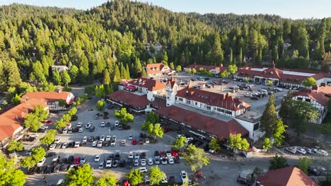 aerial pullback over lake arrowhead village busy with people during sunset and a view of the lake aerial pullback dolly 60fps