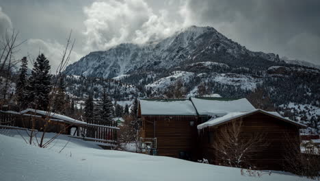 Zeitraffer,-Hölzernes-Berghaus-In-Idyllischer-Weißer-Schneelandschaft-Mit-Wolken,-Die-Sich-Um-Den-Gipfel-Bewegen