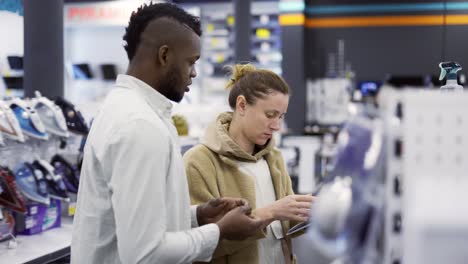 shot assistant giving advice to woman in store