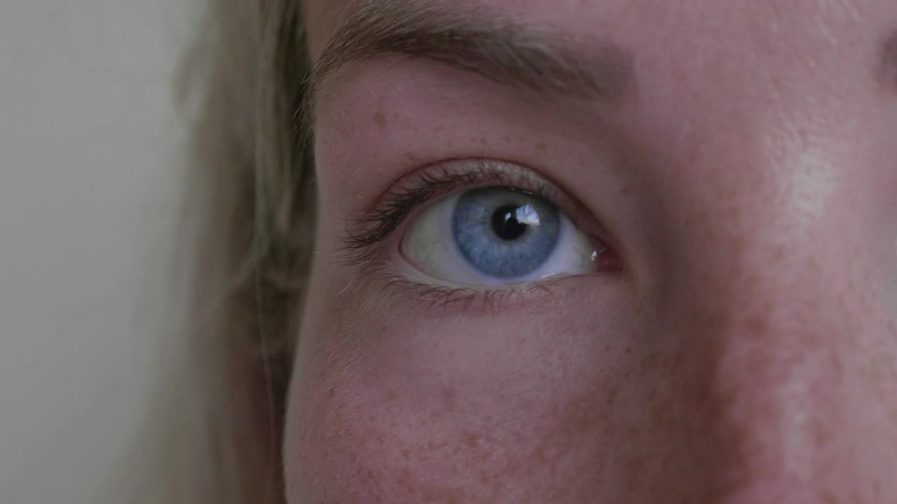 Jonge Kaukasische vrouw die een contactlens in haar rechteroog inbrengt, close-up