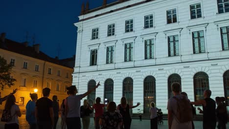 spectacular nighttime projection art show: community members in awe as stunning visuals illuminate historic building facades with colorful imagery and engaging designs