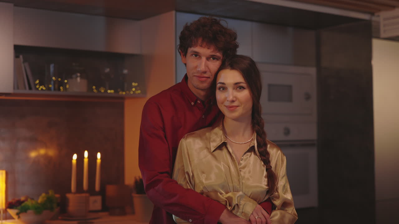 Romantic Couple Embracing in a Cozy Kitchen with Candlelight