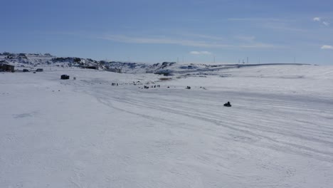 Moto-De-Nieve-En-El-Lago-Cildid-De-Hielo-Congelado-Conduciendo-Hacia-Los-Caballos