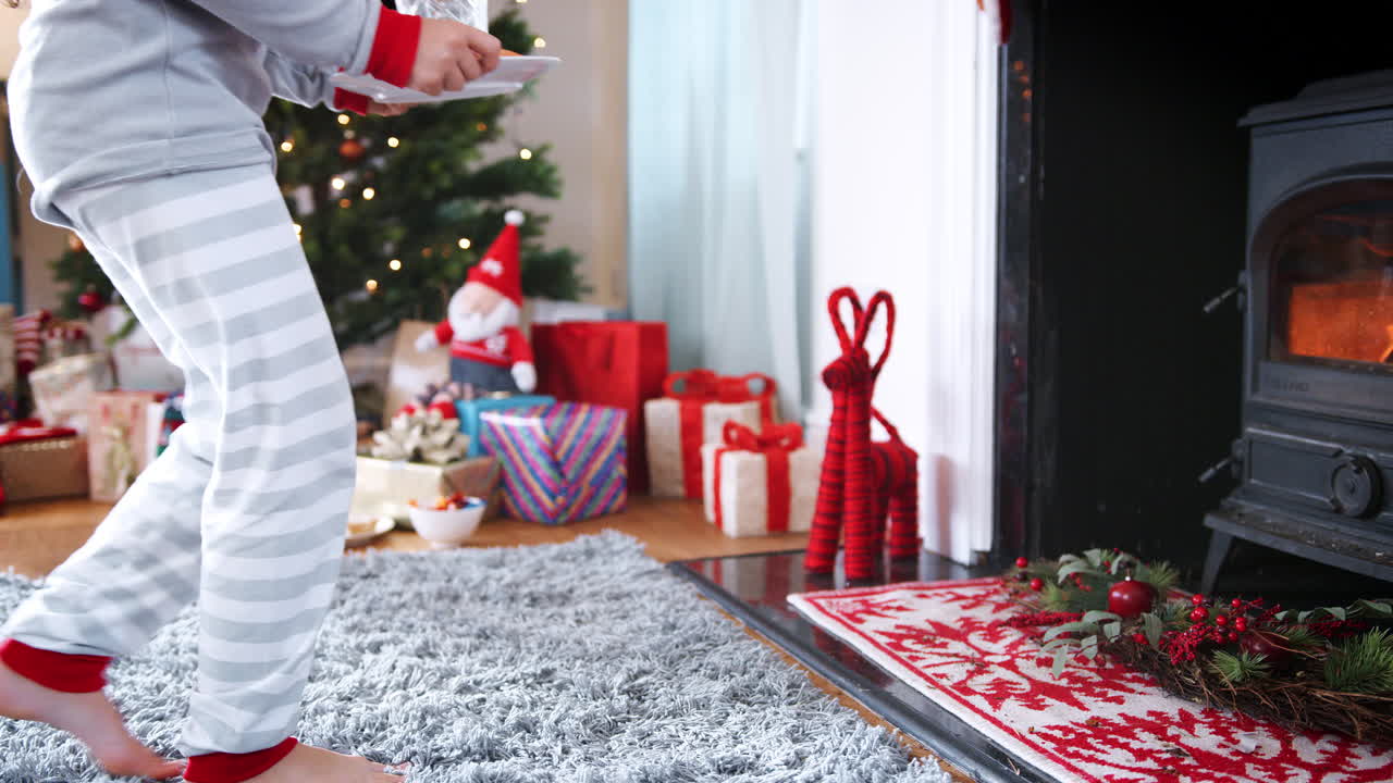 una chica preparando una tarta de carne picada con zanahoria y un vaso de leche para papá noel en la víspera de navidad.