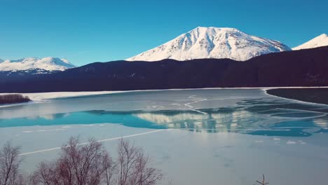 video de drones de 4k de montañas cubiertas de nieve junto a un lago en alaska durante el invierno