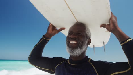 senior man with a surfboard at the beach