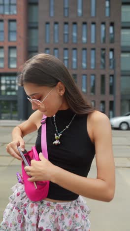 young woman using smartphone on city street