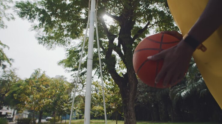 Atleta maschio che tira la palla in un canestro da streetball