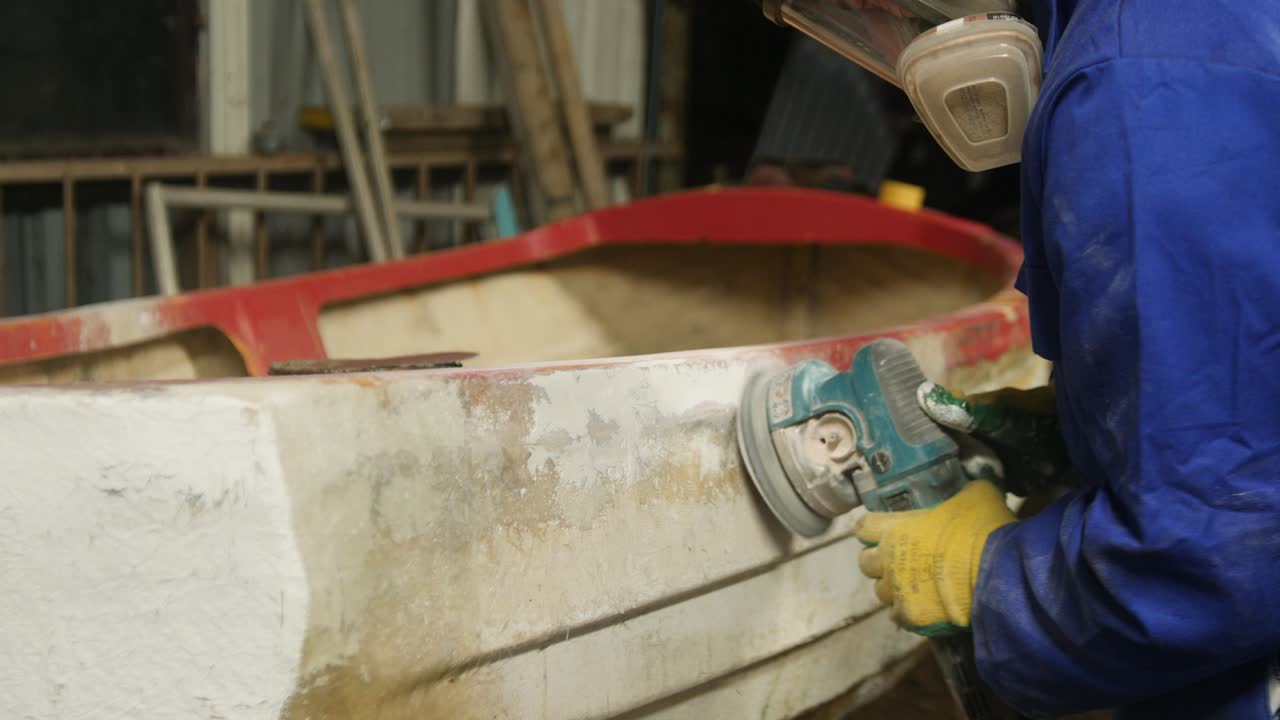 Sanding glass fiber boat hull using orbital sander
