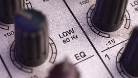 Increasing-Low-Frequency-Sound-Gain-on-Mixing-Console,-Macro-Close-Up