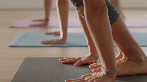 close-up-group-of-women-in-yoga-class-practicing-downward-facing-dog-pose-training-healthy-lifestyle-exercising-enjoying-fitness-studio-meditation