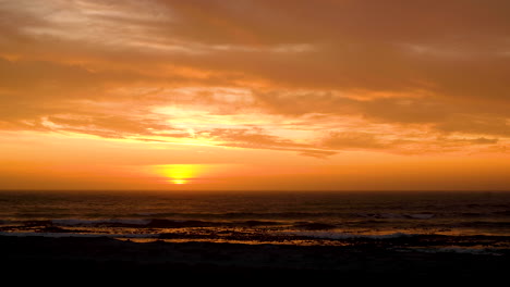 Sonnenuntergang-über-Dem-Meer,-Leichte-Wolken-Sorgen-Für-Einen-Beeindruckenden-Goldenen-Himmel