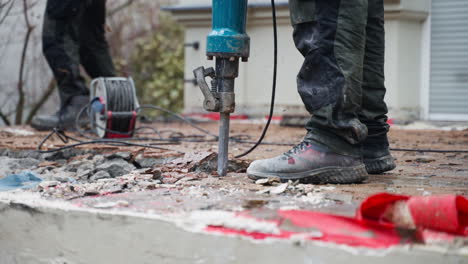 Ein-Arbeiter-Auf-Einer-Baustelle,-Der-Mit-Einem-Pneumatischen-Presslufthammer-Asphalt--Oder-Betondecken-Abreißt,-Seitenansicht