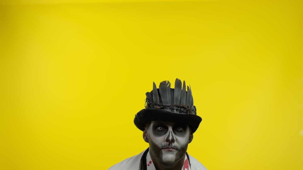 Sinister man with professional Halloween skeleton makeup greeting someone, say hello, hi, welcome