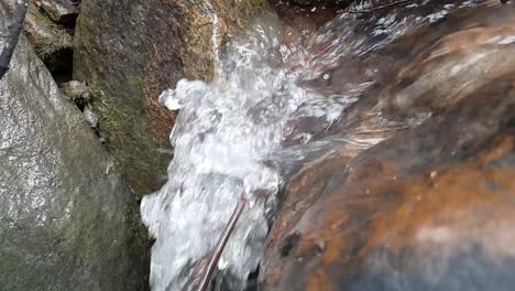 flowing-mountain-spring-water-stream-running-down-huge-sandstone-slabs-of-rock,-crystal-clear-drinking-water,-meditation-tranquil-and-peaceful-calming-outdoor-nature-scene-footage