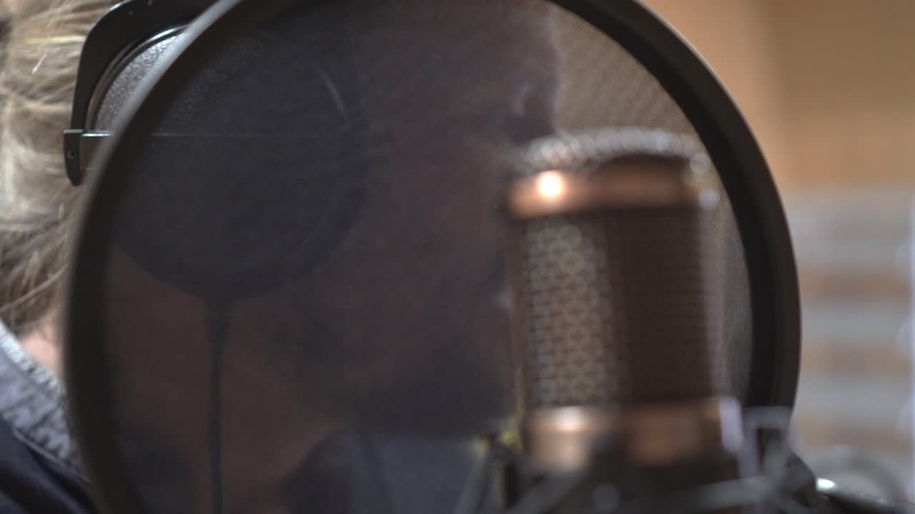 Face of singer and studio microphone, extreme closeup