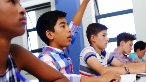 student raising hand in classroom