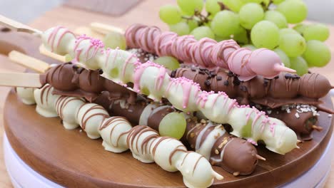 grapes on sticks covered with chocolate and white chocolate with sprinkles on top