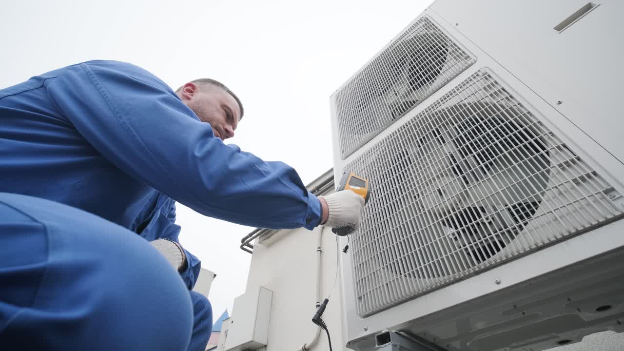 Technician uses a thermal imaging infrared thermometer to check the condensing unit heat exchanger