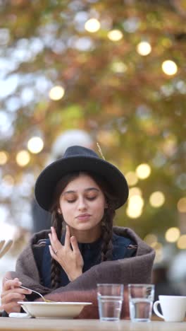 woman eating soup outdoors