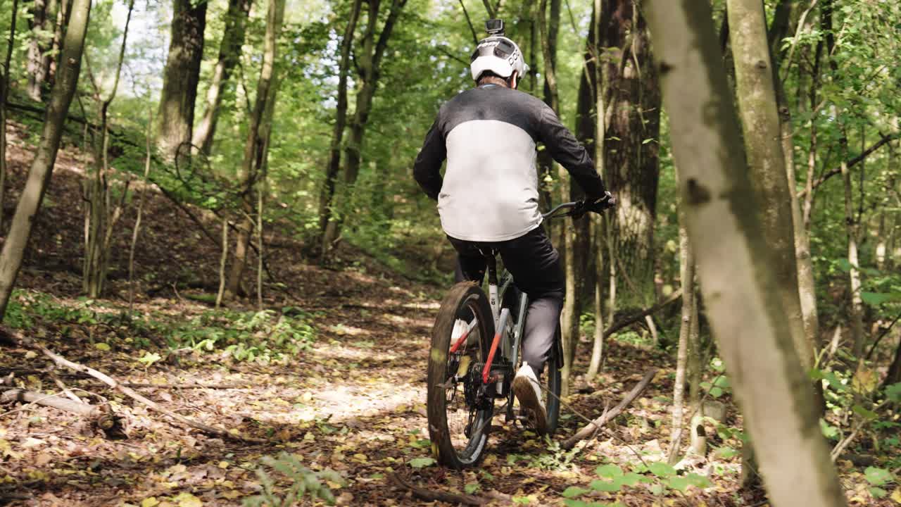 Professional rider put on protective gloves and start riding MTB bike in forest
