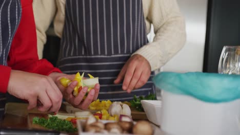 video of happy caucasian couple peeling vegetables in the kitchen