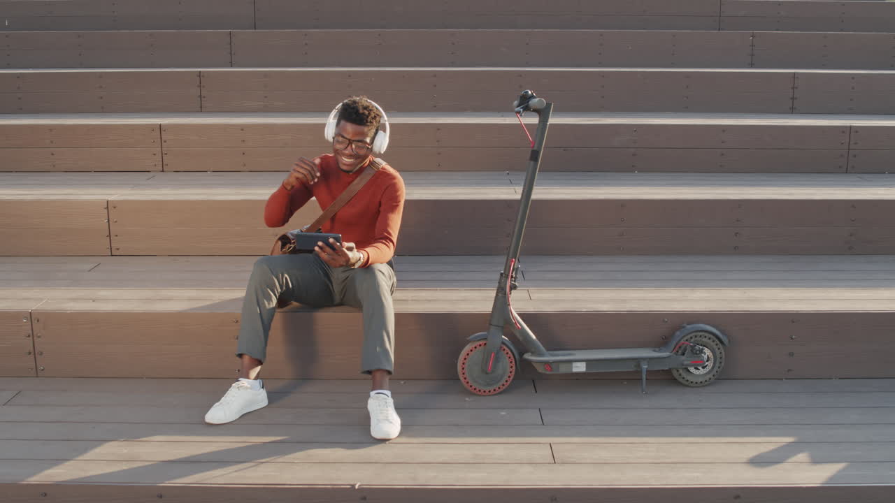 Cheerful African American Man Watching Music Videos Outdoors