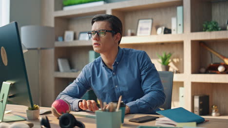 creador enfocado escribiendo en el teclado de la computadora en el interior de la oficina. hombre trabajando