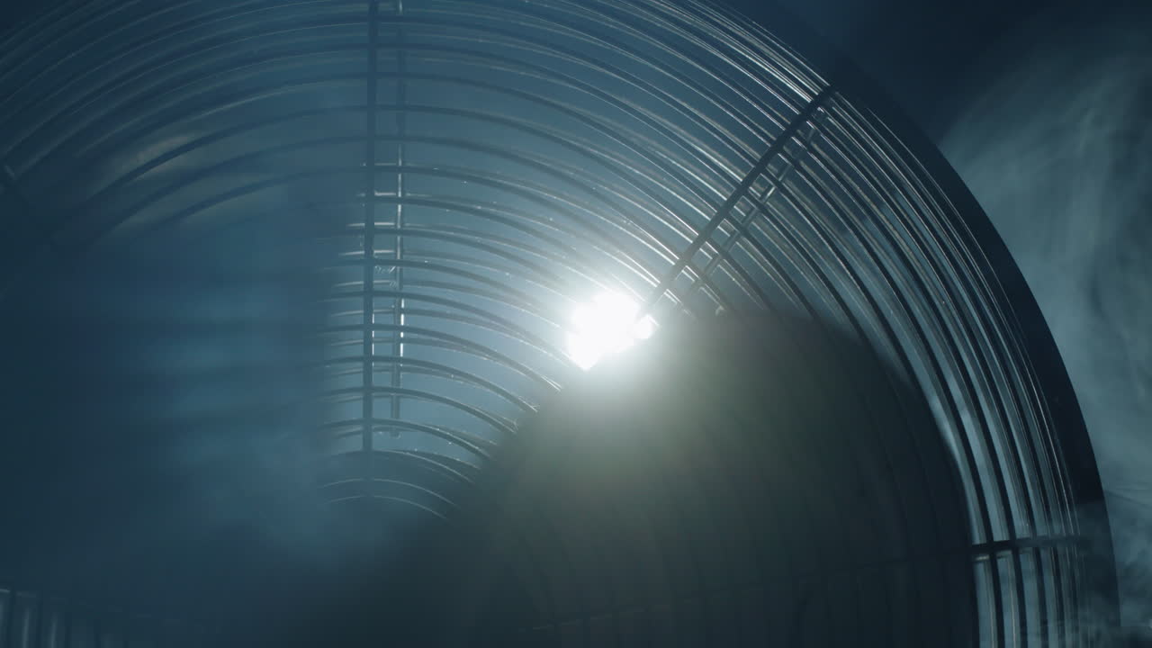 las palas de los ventiladores giran en rayos de luz y niebla.