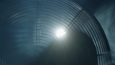 fan blades rotate in rays of light and fog. close-up shot