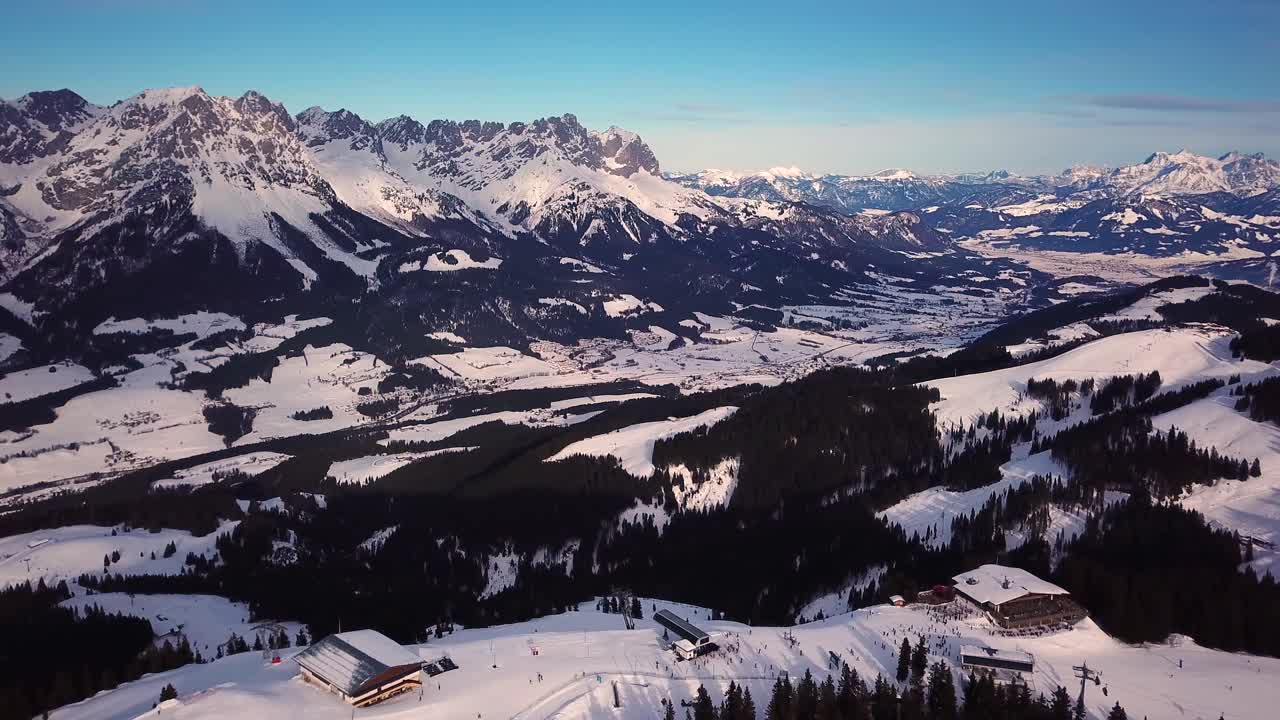 montañas nevadas en nubes bajas y cielo azul al atardecer en invierno