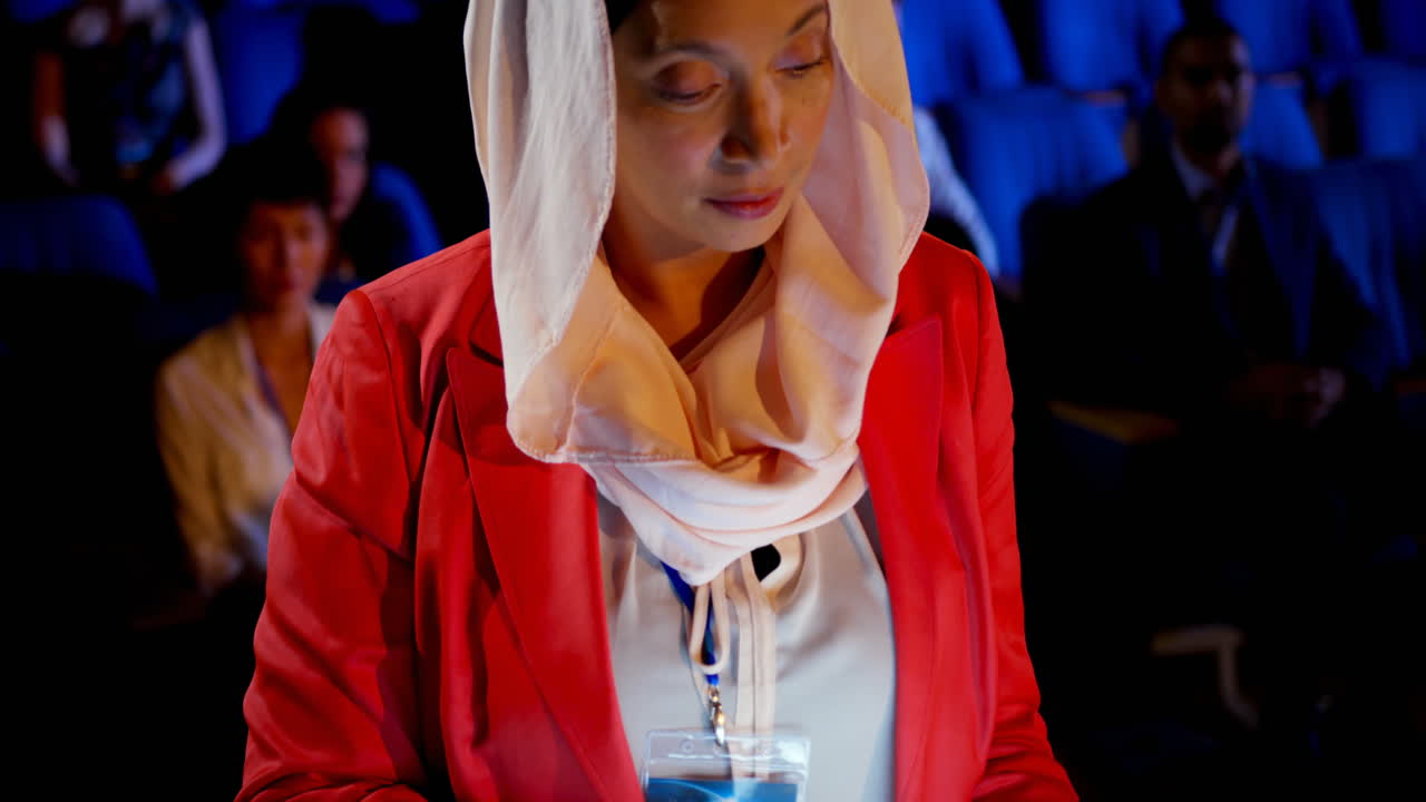 donna d'affari che utilizza un tablet digitale in un seminario nell'auditorium 4k