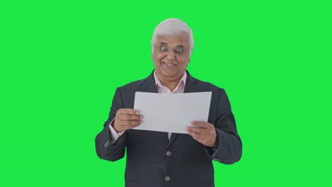 el gerente senior indio feliz leyendo informes pantalla verde