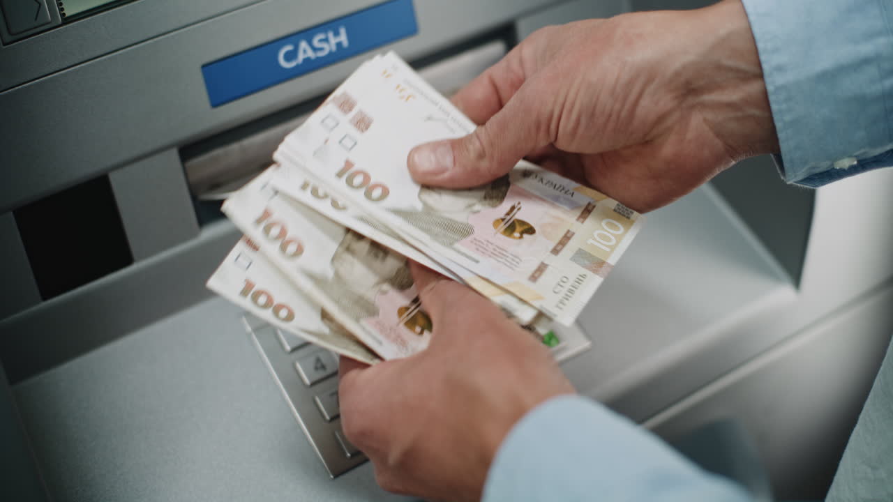 Человек, снимающий деньги из банкомата.