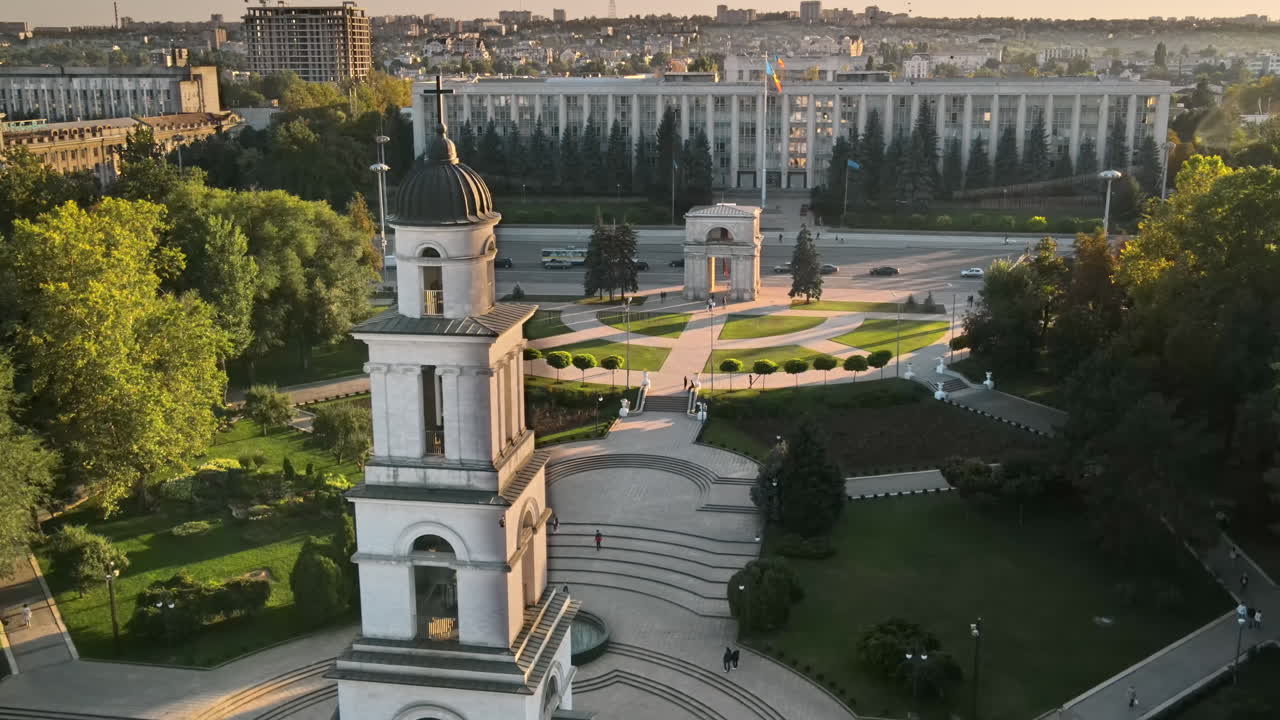 Aerial drone view of Chisinau downtown at sunset. Panorama view of Goverment building, Triumph Arch, Cathedral and bell tower, walking people. Moldova