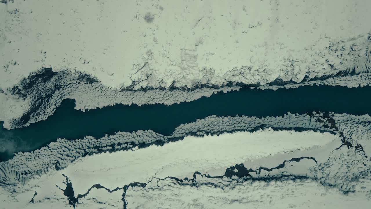 Veduta aerea di un fiume ghiacciato che scorre attraverso un paesaggio innevato