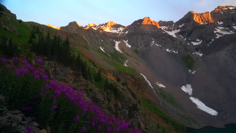 Cinematic-slow-motion-pan-right-stunning-light-light-golden-hour-sunset-on-Mount-Sniffels-Peaks-summer-colorful-Colorado-Telluride-summer-purple-wildflower-Blue-Lake-14er-snow-melting-Rocky-Mountains
