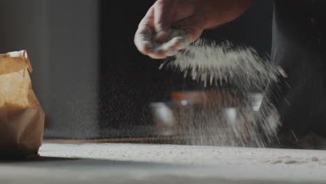 chef sprinkling flour on table