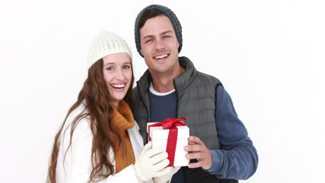 casual couple in warm clothing holding gift