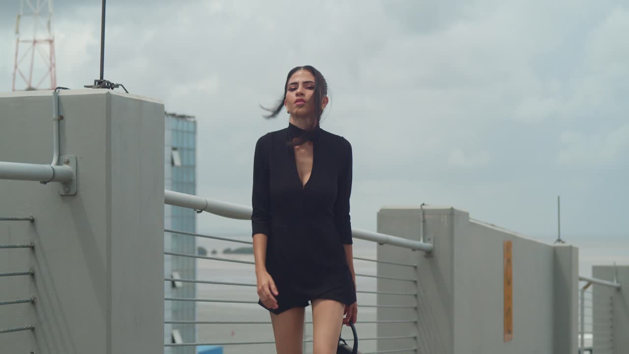 A woman posing in a black dress.