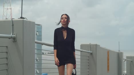 a woman posing in a black dress.