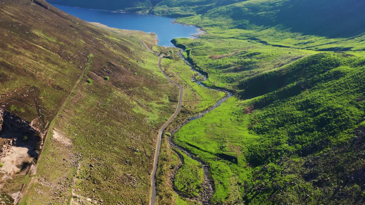 Aerial Descent Over Silent Valley With Curved River and Grassy Hills on a Bright Summer Day