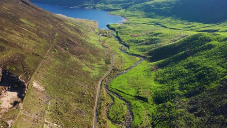 Aerial Descent Over Silent Valley With Curved River and Grassy Hills on a Bright Summer Day